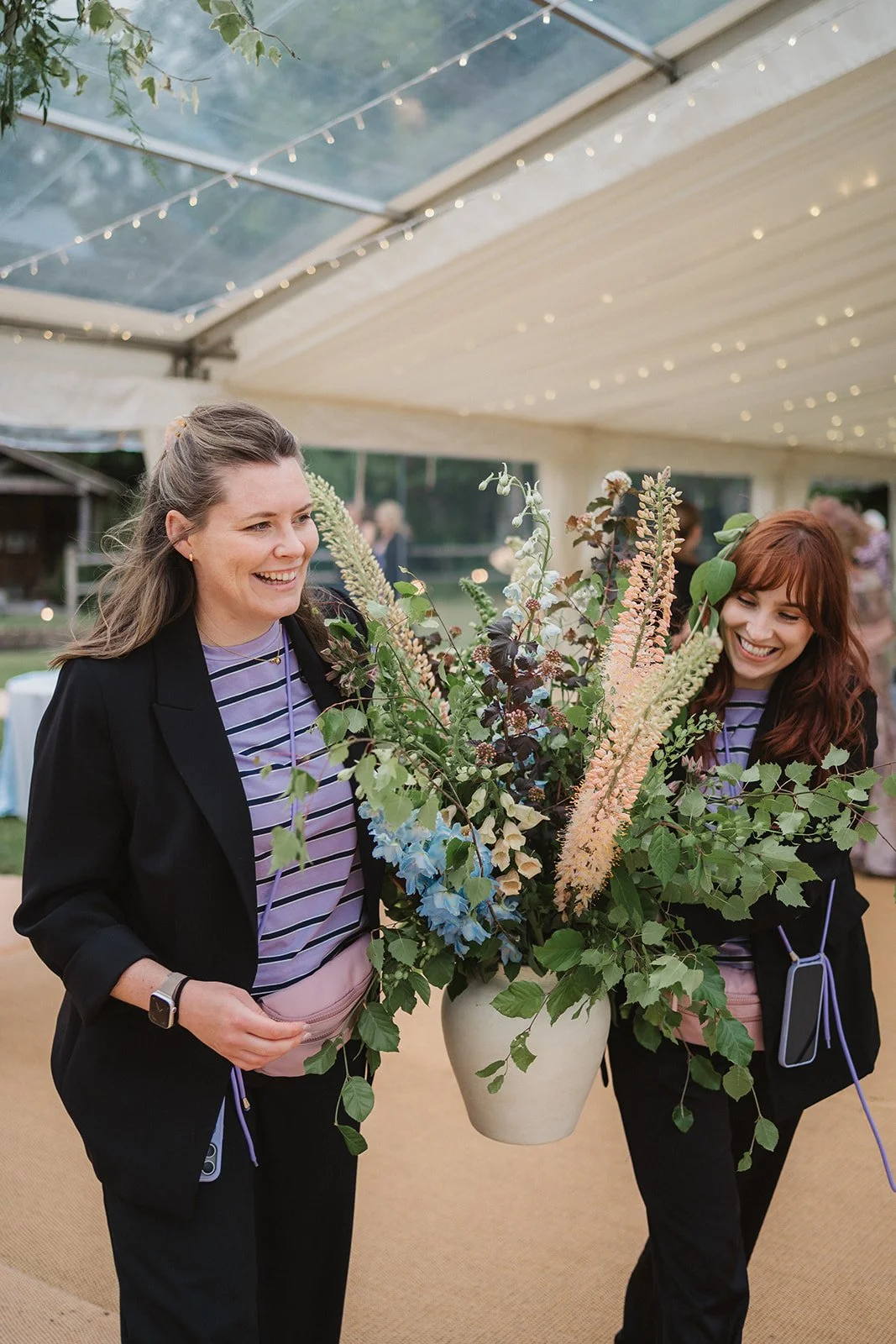 Emma and her assistant moving florals at a luxury marquee wedding