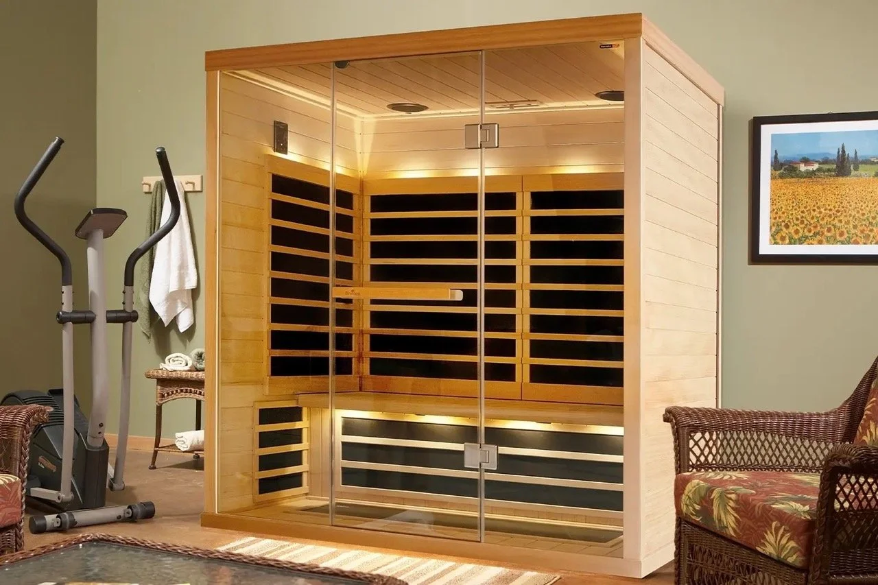 Home gym with an infrared sauna, exercise bike, wicker furniture, and sunflower artwork.