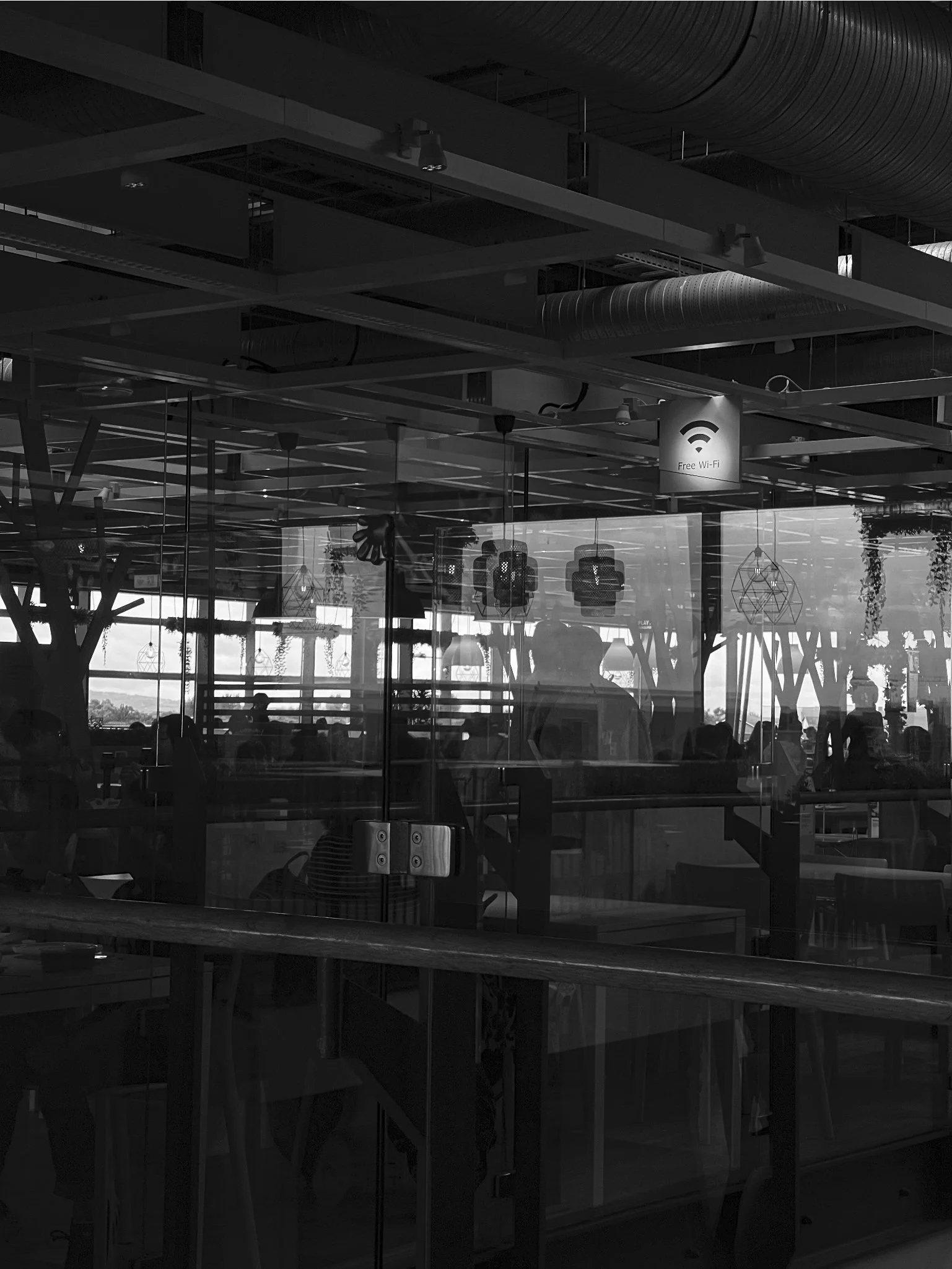 Image of a café interior showing reflections from a front window and through to a rear window. Free wifi sign