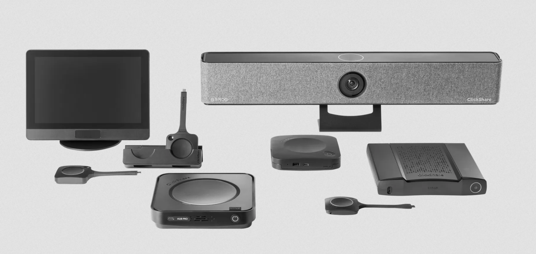 Verschiedene Videokonferenz- und Präsentationstechnologie, darunter Monitore, Kameras, Mikrofone und Steuergeräte, auf einer weißen Oberfläche.