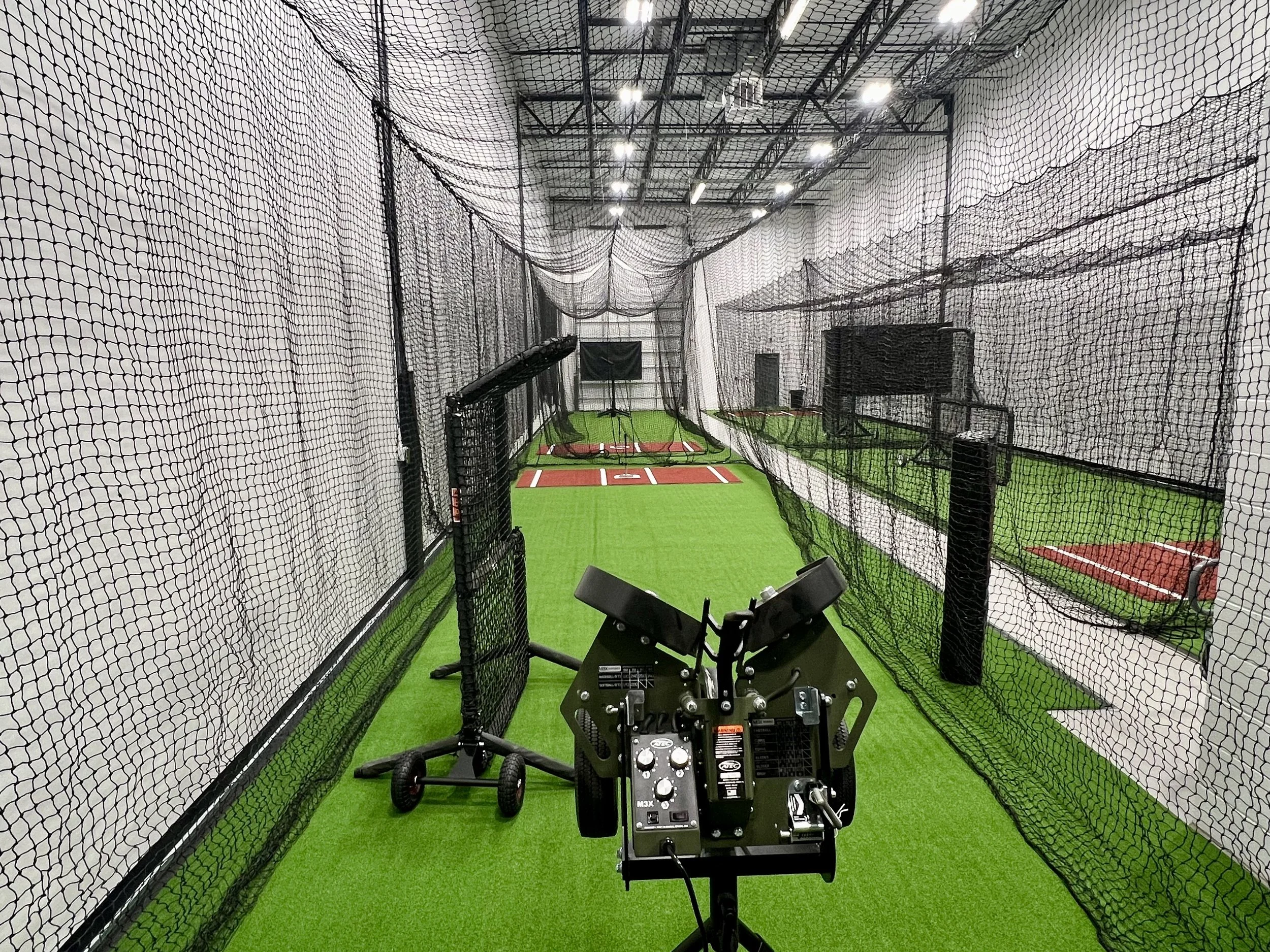 Indoor baseball and softball batting cage with artificial green turf, black netting, and pitching machines. Brownsburg, Indiana. Avon, Indiana. Plainfield, Indiana. Danville, Indiana. Mooresville, Indiana. Pittsboro, Indiana. Indianapolis, Indiana.
