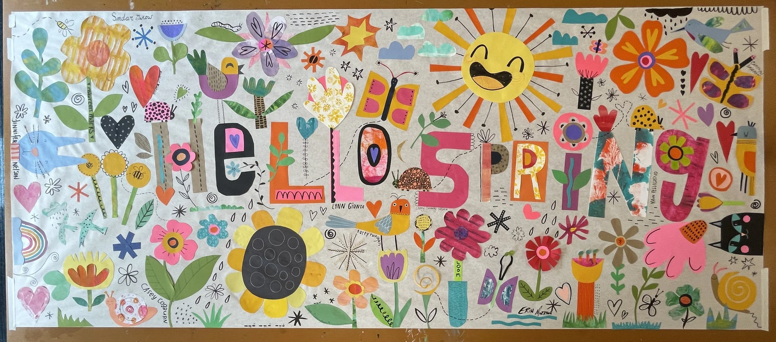 Collaborative collage reading Hello Spring, filled with paper flowers, hearts, butterflies and a smiling sun.
