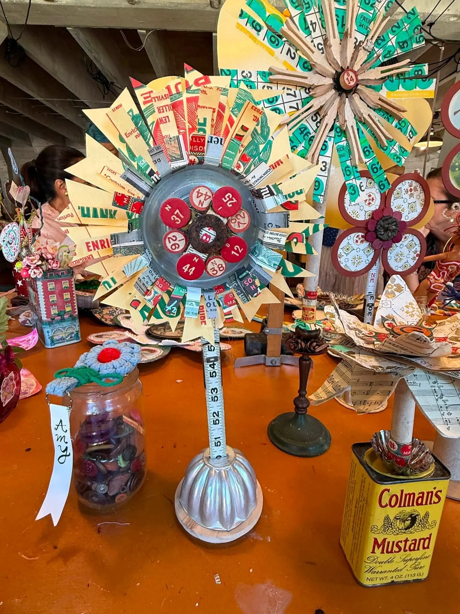 Retreat artists gathered around a studio table covered with handmade paper and metal flowers in The Smiley Manse barn
