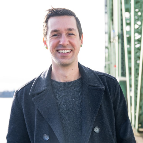 Public Policy Director Bryan Stebbins smiles outside with the I-5 bridge in the background