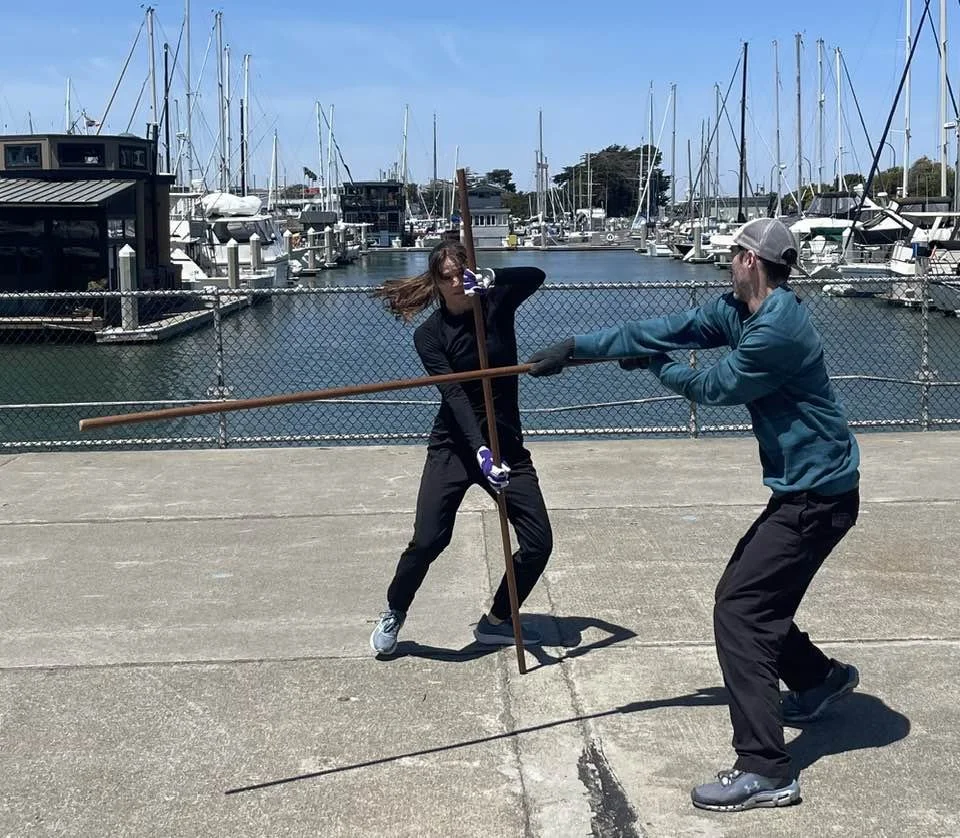 Natalie Renier-Bertolucci practicing quarterstaff during a stage combat practice with her fight partner.