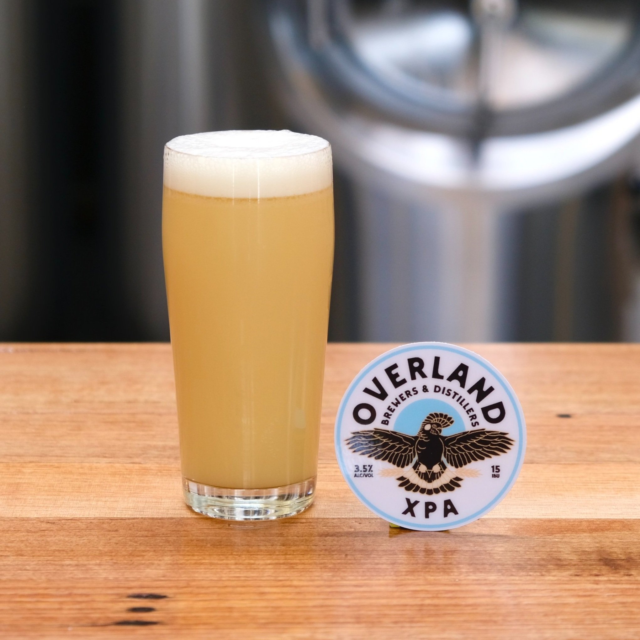 Pint of hazy yellow beer and tap decal with black cockatoo logo