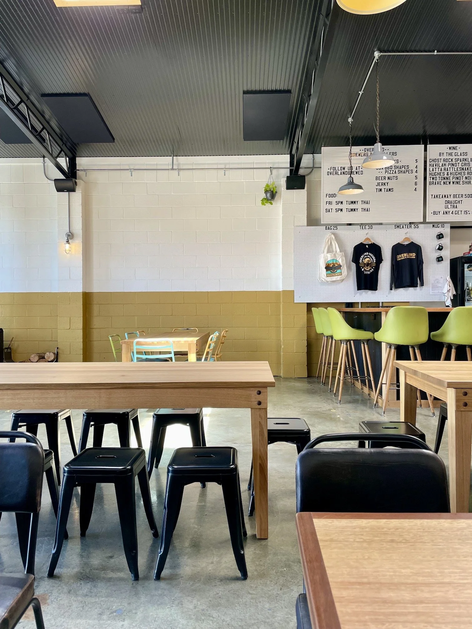 bar interior with wooden tables and black and green stools