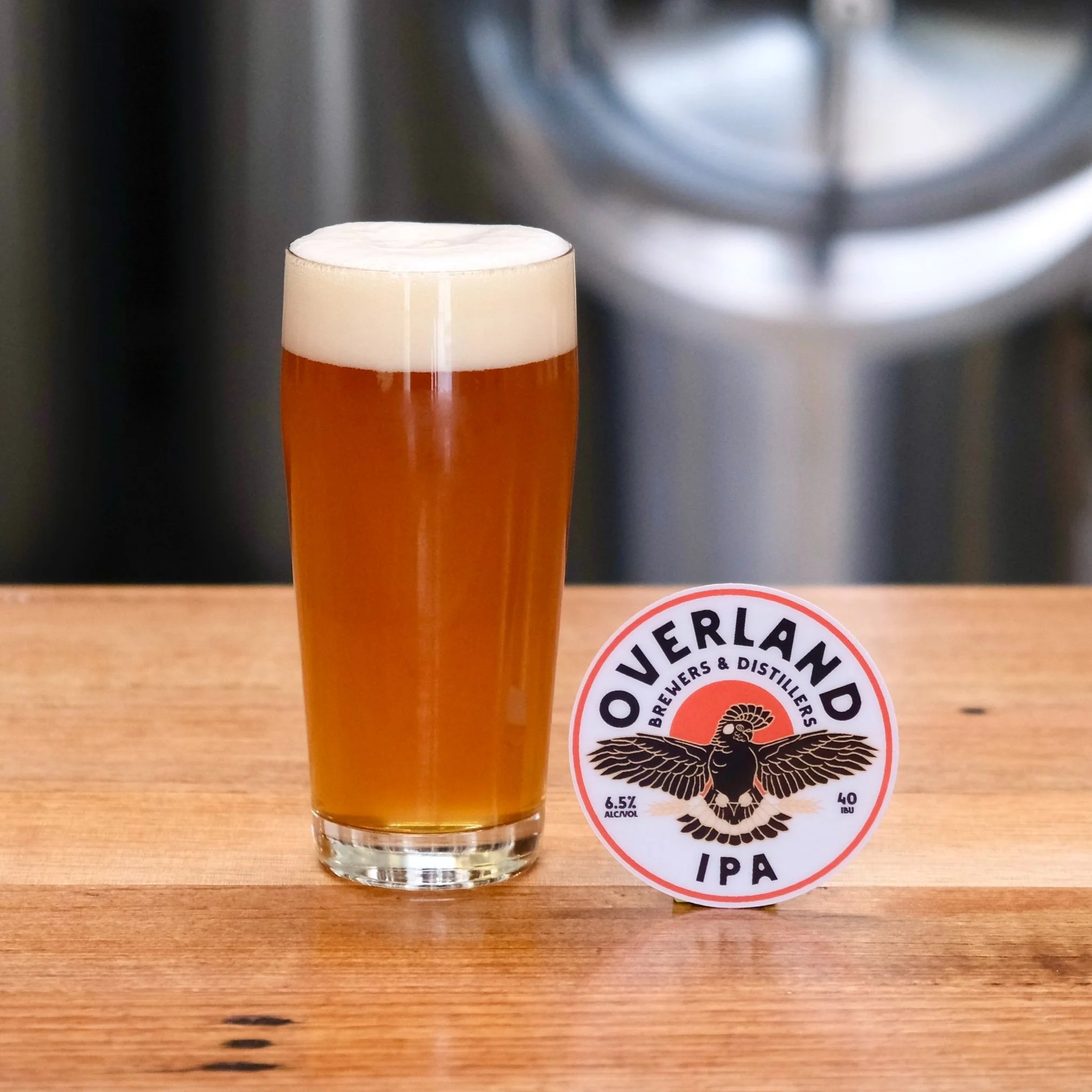Pint of dark amber beer and tap decal with black cockatoo logo