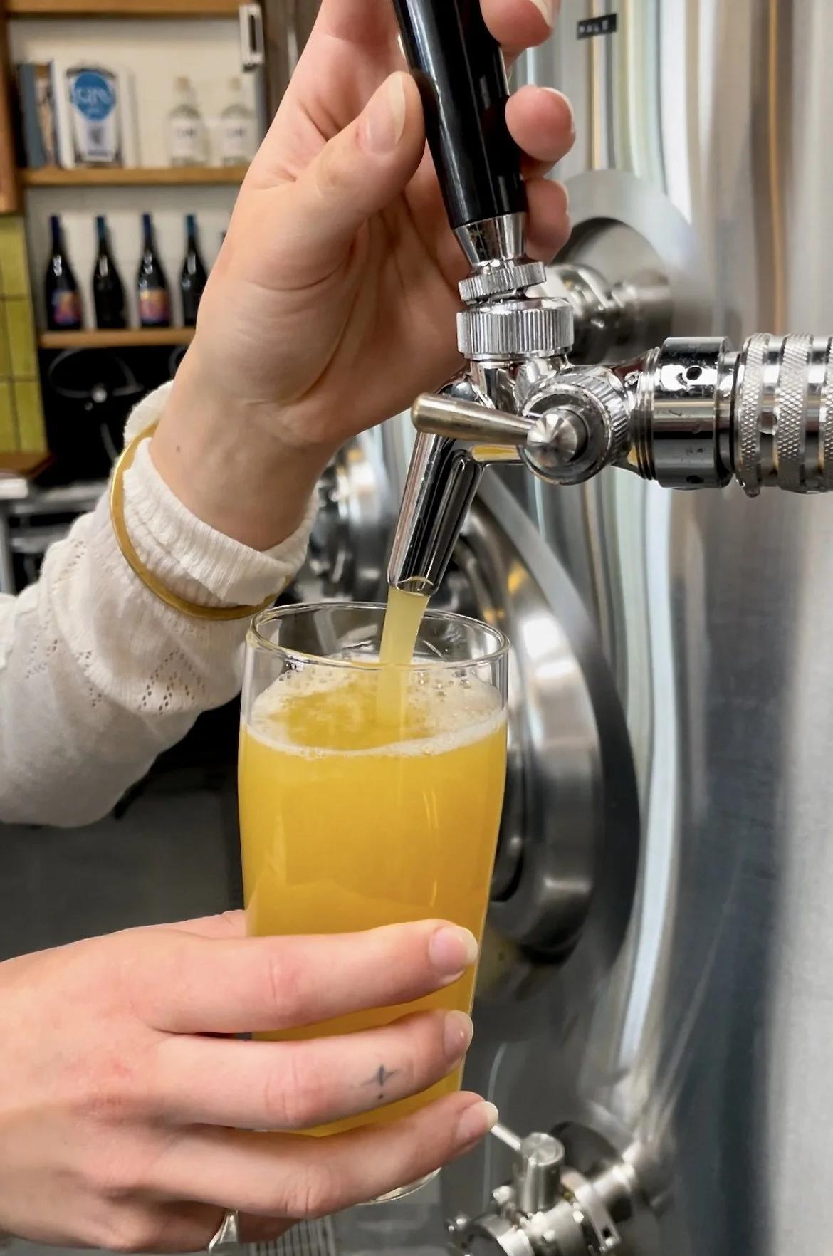 woman's hand pouring passionfruit sour beer from tap