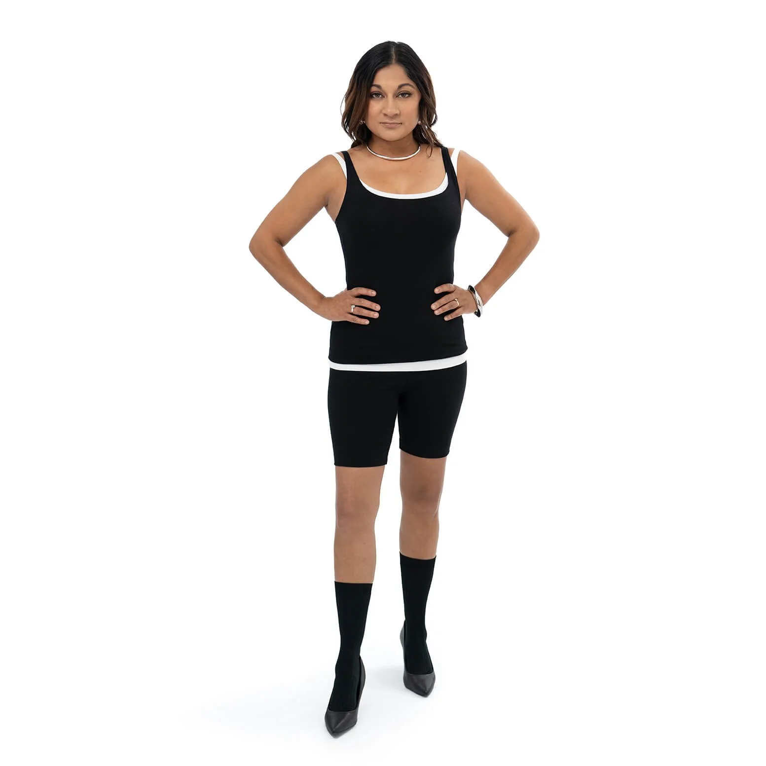 woman poses while wearing a black singlet top with black bike shorts