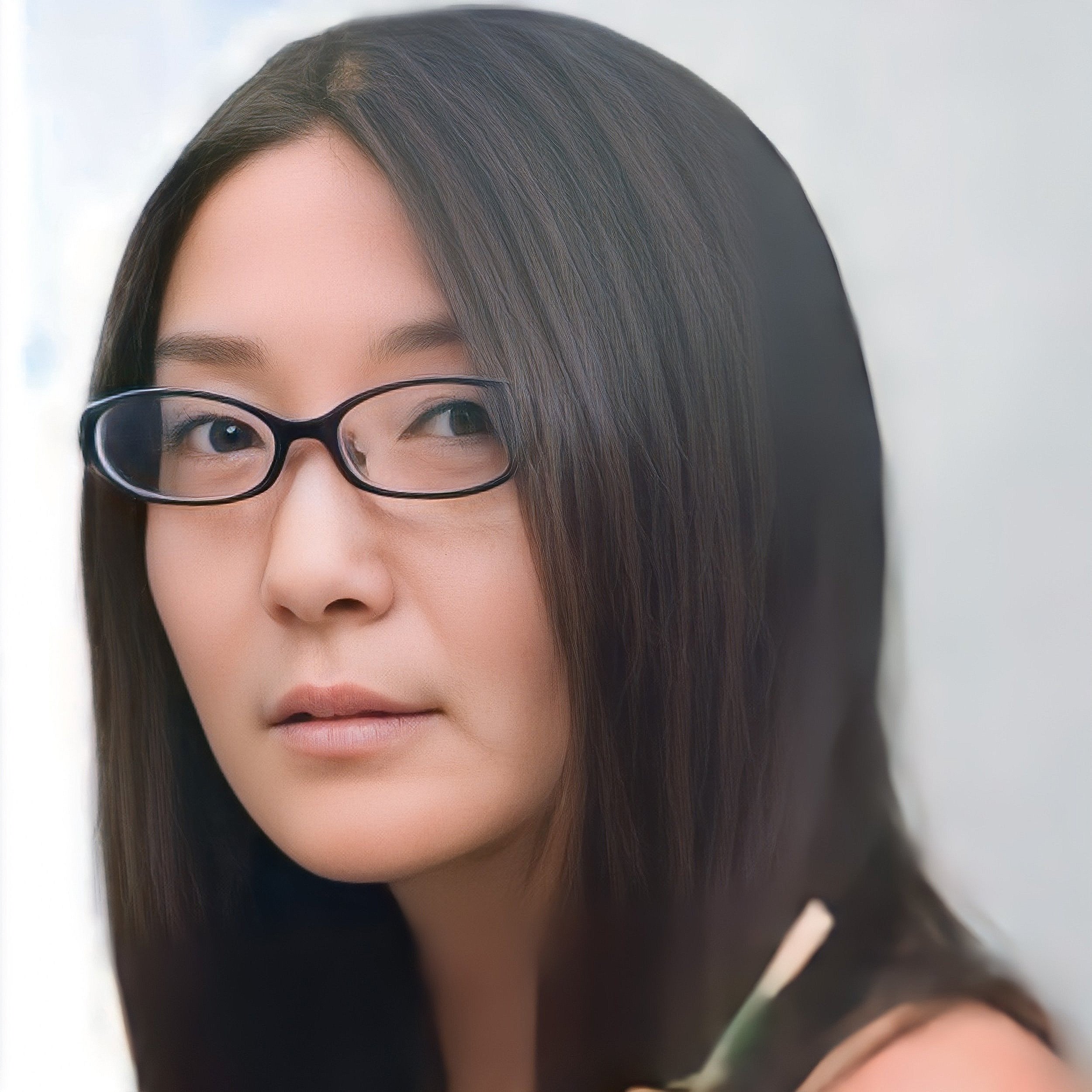 Close-up of a woman with straight dark hair, glasses, and light makeup, looking slightly to the side.