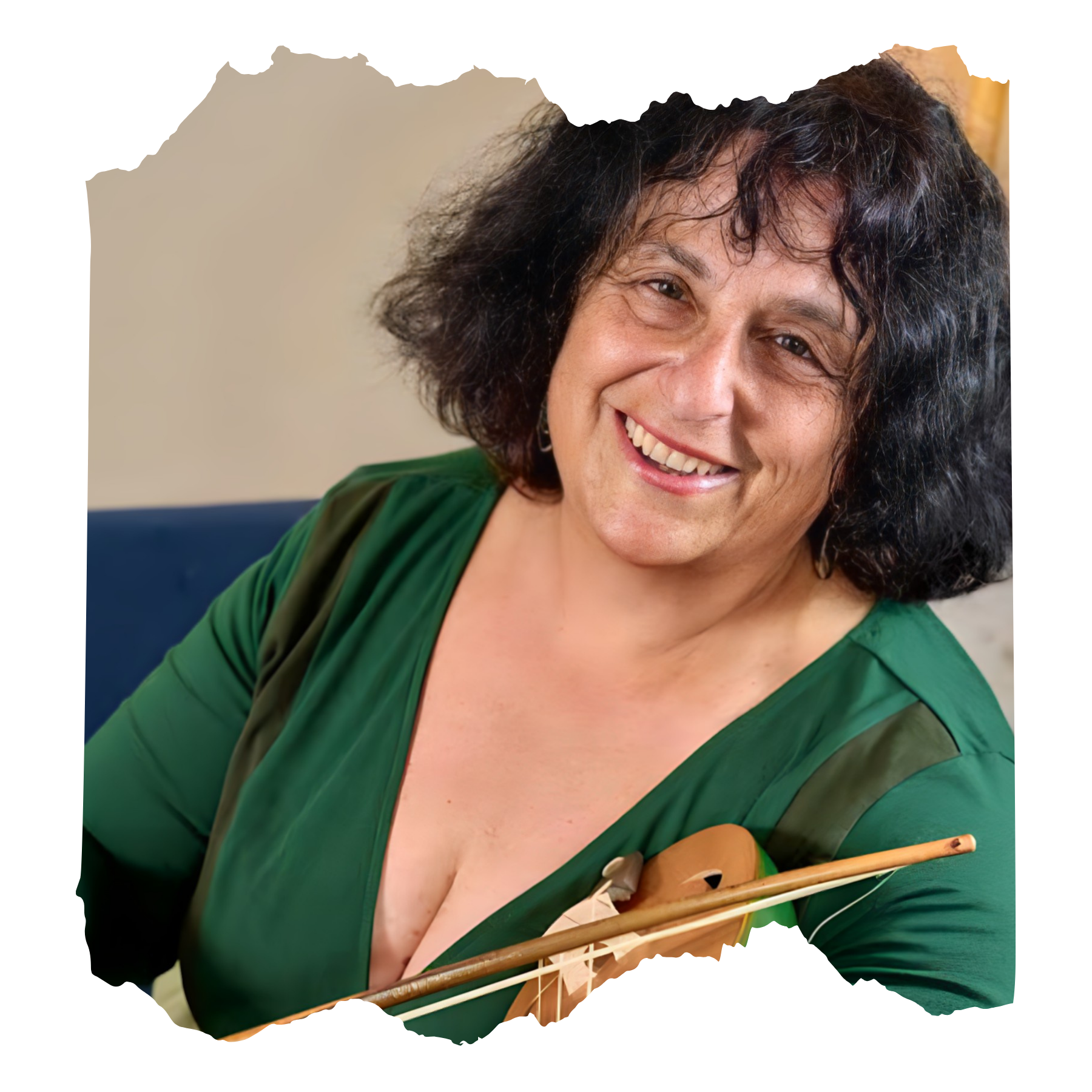 A smiling woman with dark curly hair wearing a green dress, sitting on a blue chair, holding a violin and bow.