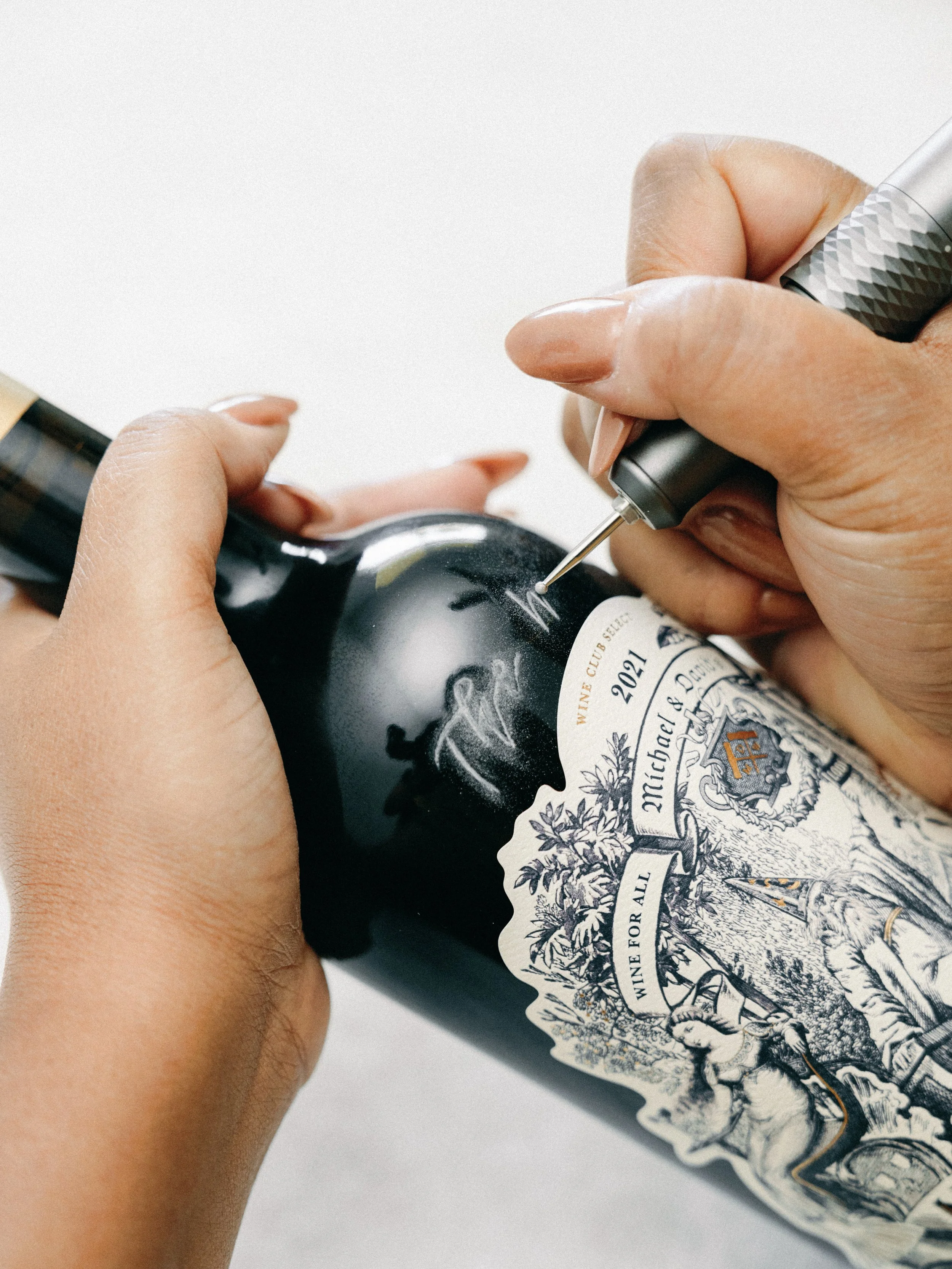 Live hand engraving on wine bottles at a Northern California wedding