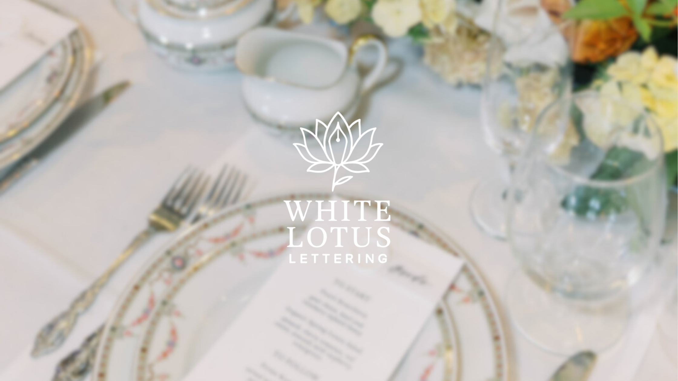 Elegant table setting with decorative plates, silverware, glassware, and floral centerpiece.