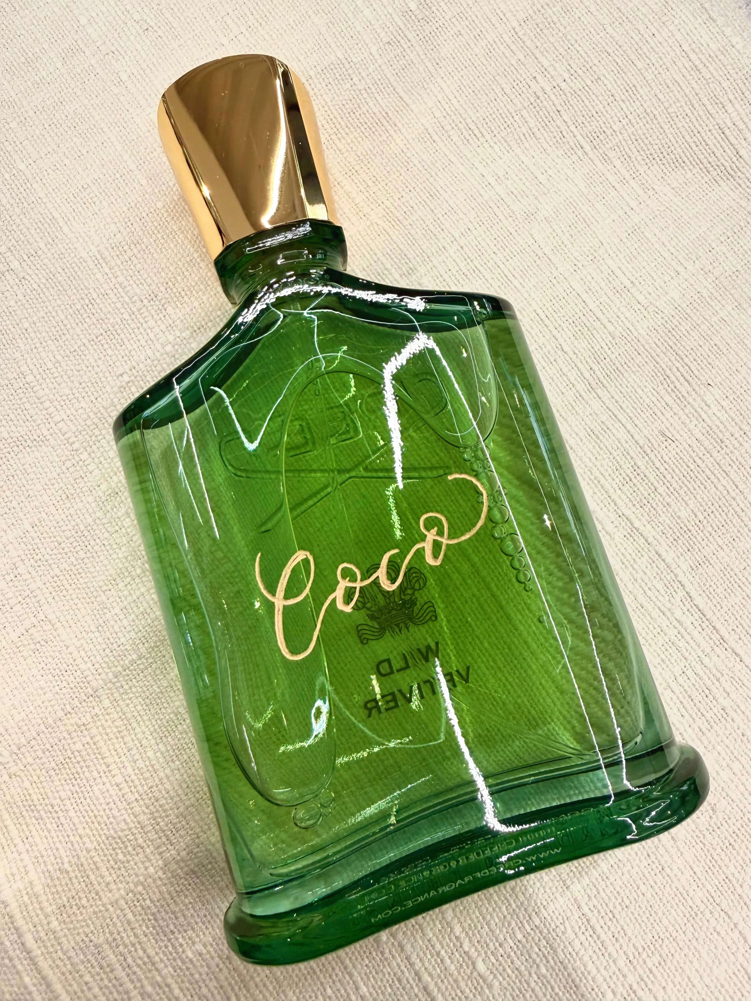 On-site engraving on a Creed Wild Vetiver green perfume bottle during a luxury brand activation event in San Francisco California