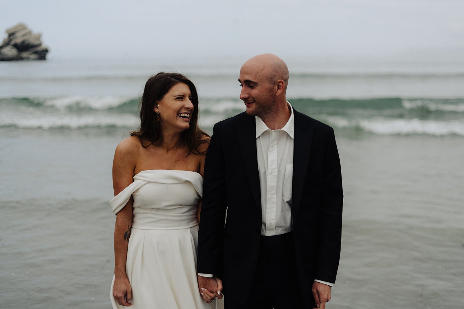 Couple laughing together as they elope in the ocean