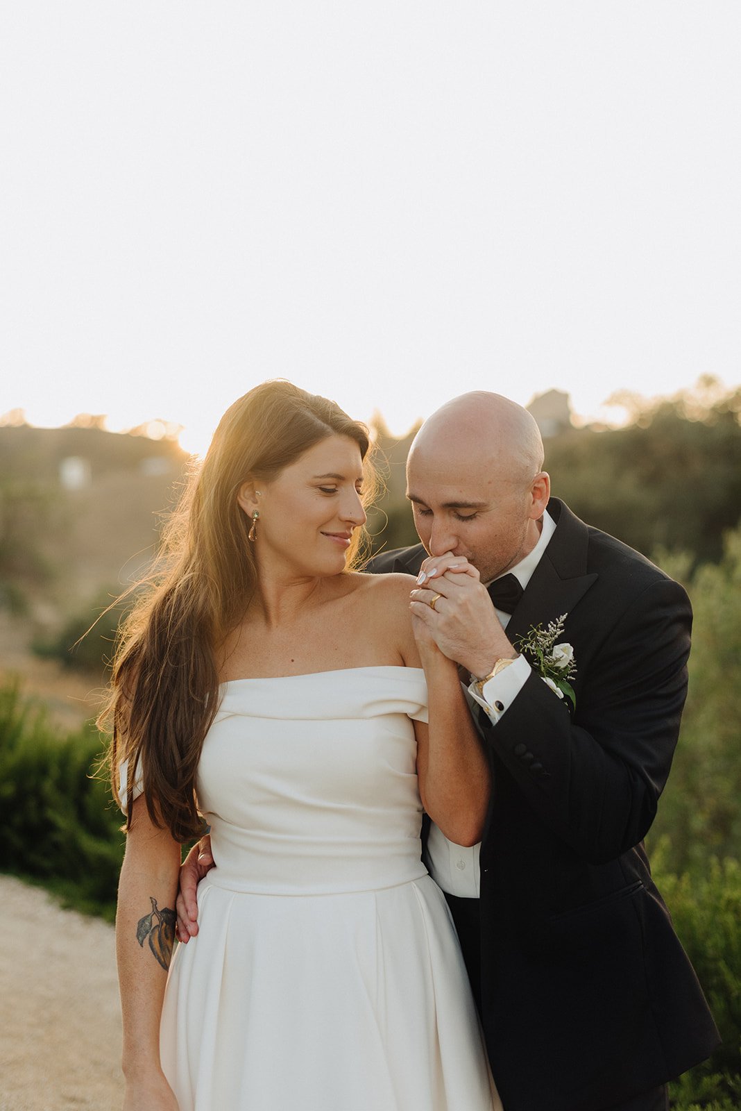 Groom kisses brides hand at Villa De Lucca