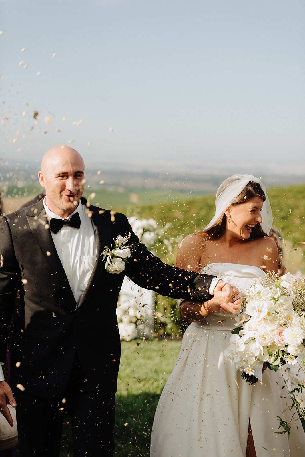 Bride and groom walking down the aisle with confetti