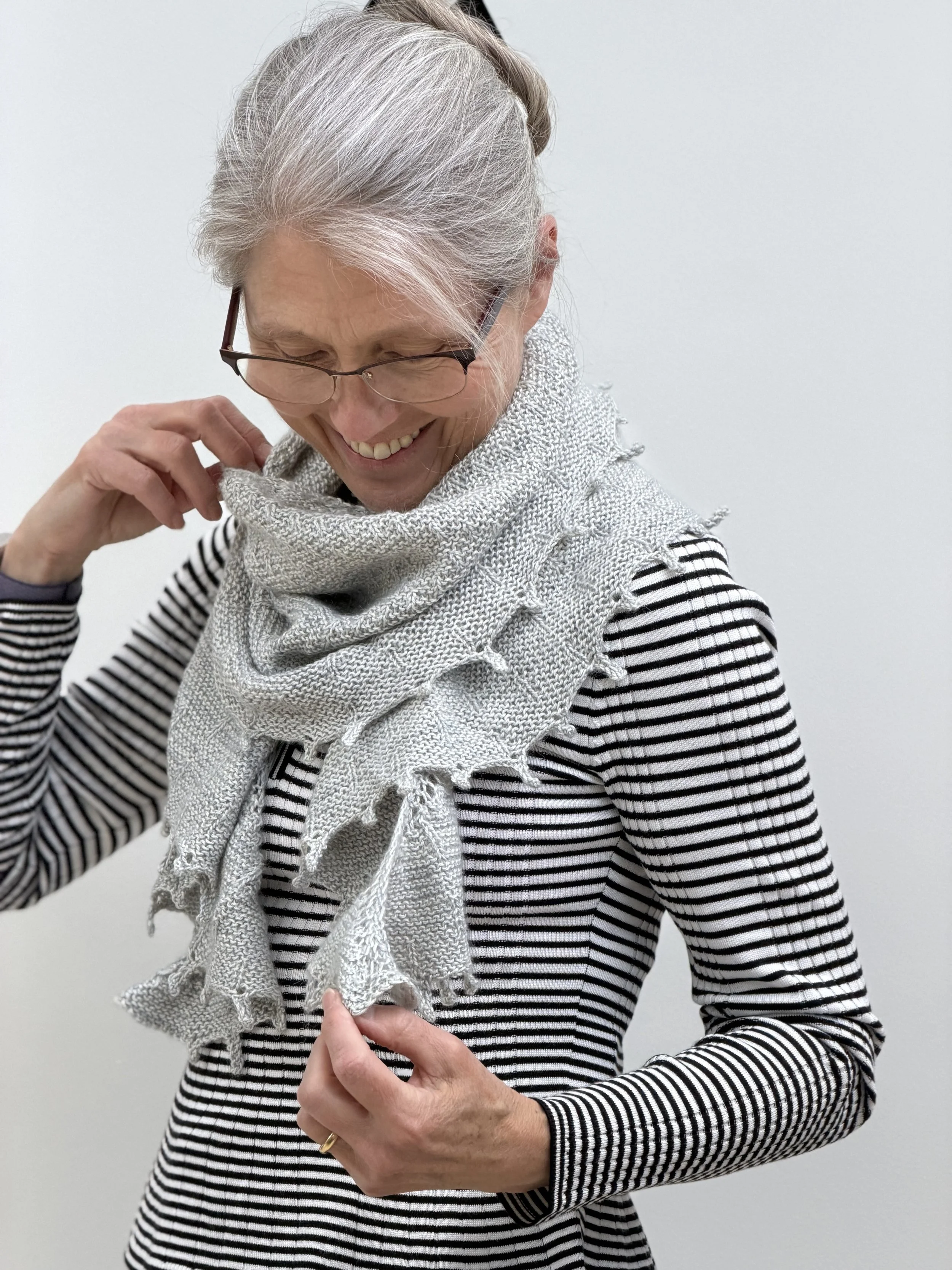 Emma is holding the icicle Shawl with two hands to show how the shawl can be wrapped around the neck