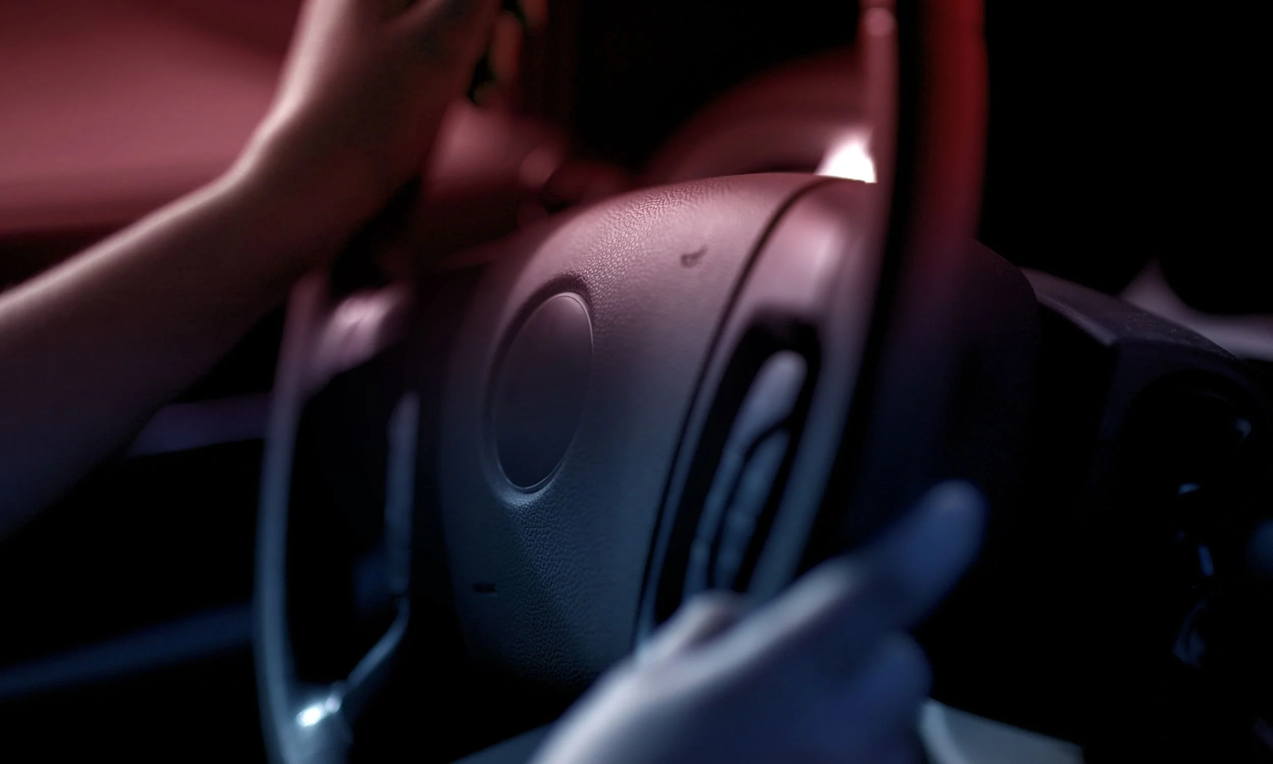Close-up of a driver holding a steering wheel at night, representing DUI arrests and impaired driving laws in Illinois