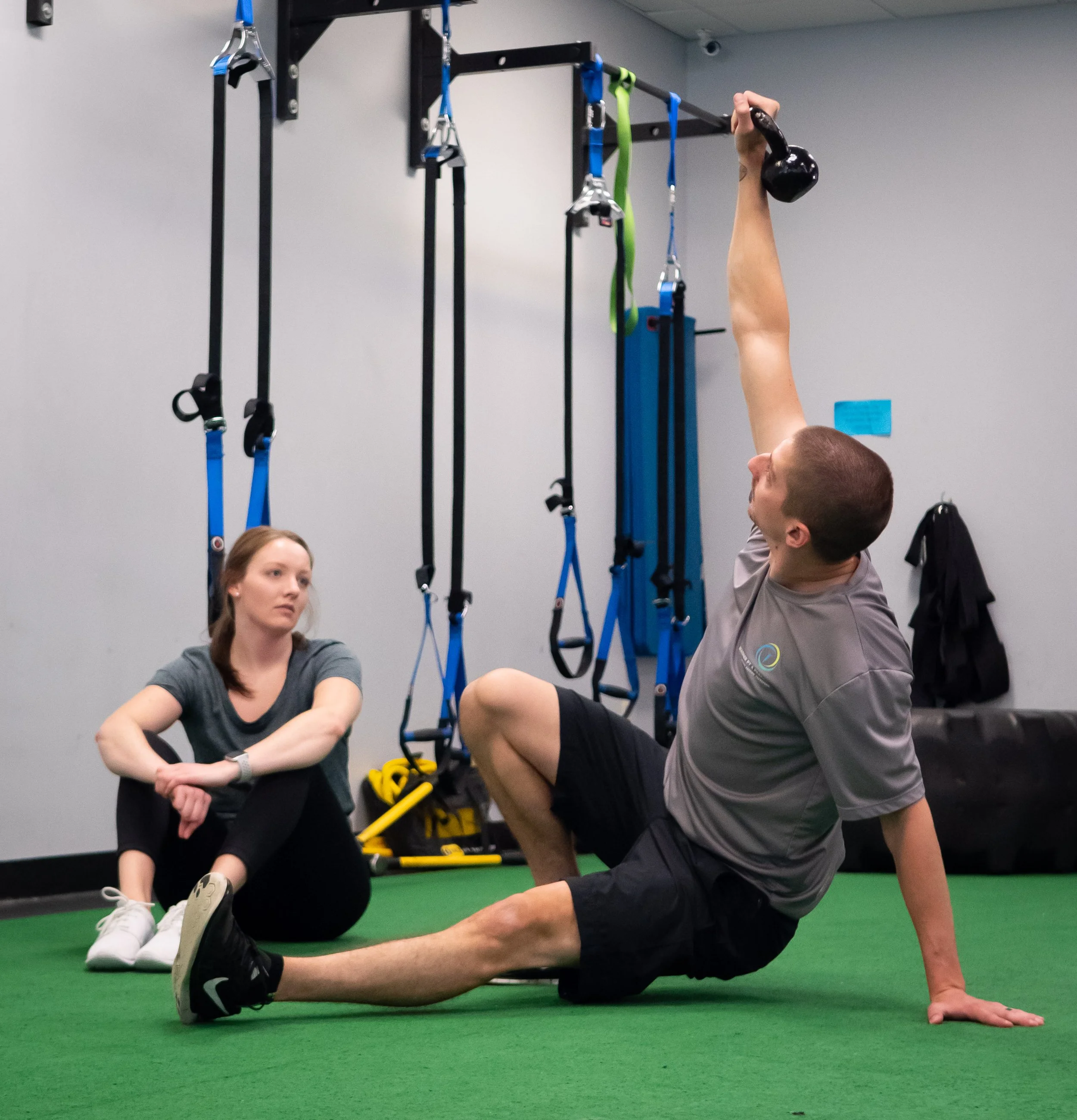 Vertigo patient watches a Physical Therapist demonstrate a vestibular rehab exercise during treatment for vestibular issues.