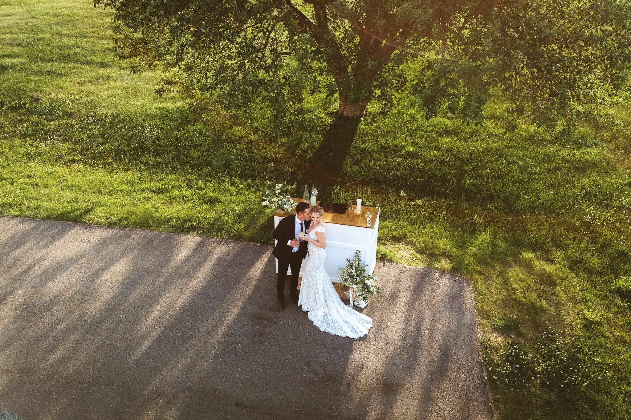 A close-up of a bride and groom holding champagne glasses, with the groom dressed in a tuxedo and the bride in a white off-shoulder dress, celebrating at a wedding.
Credit: David Lescatre Jr Photography / Lescatre Studios LLC - Based in New Hampshire