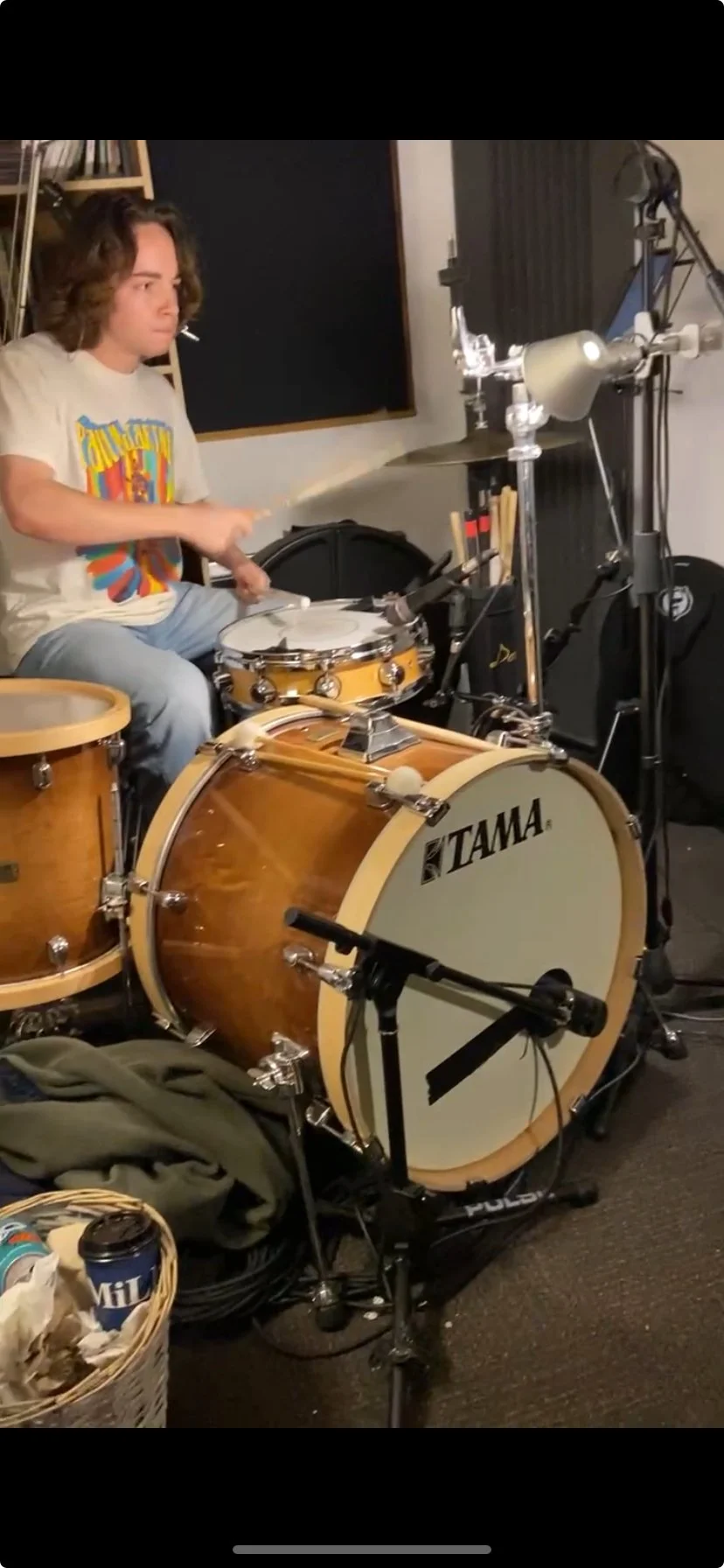 A person playing a drum set in a recording studio.
