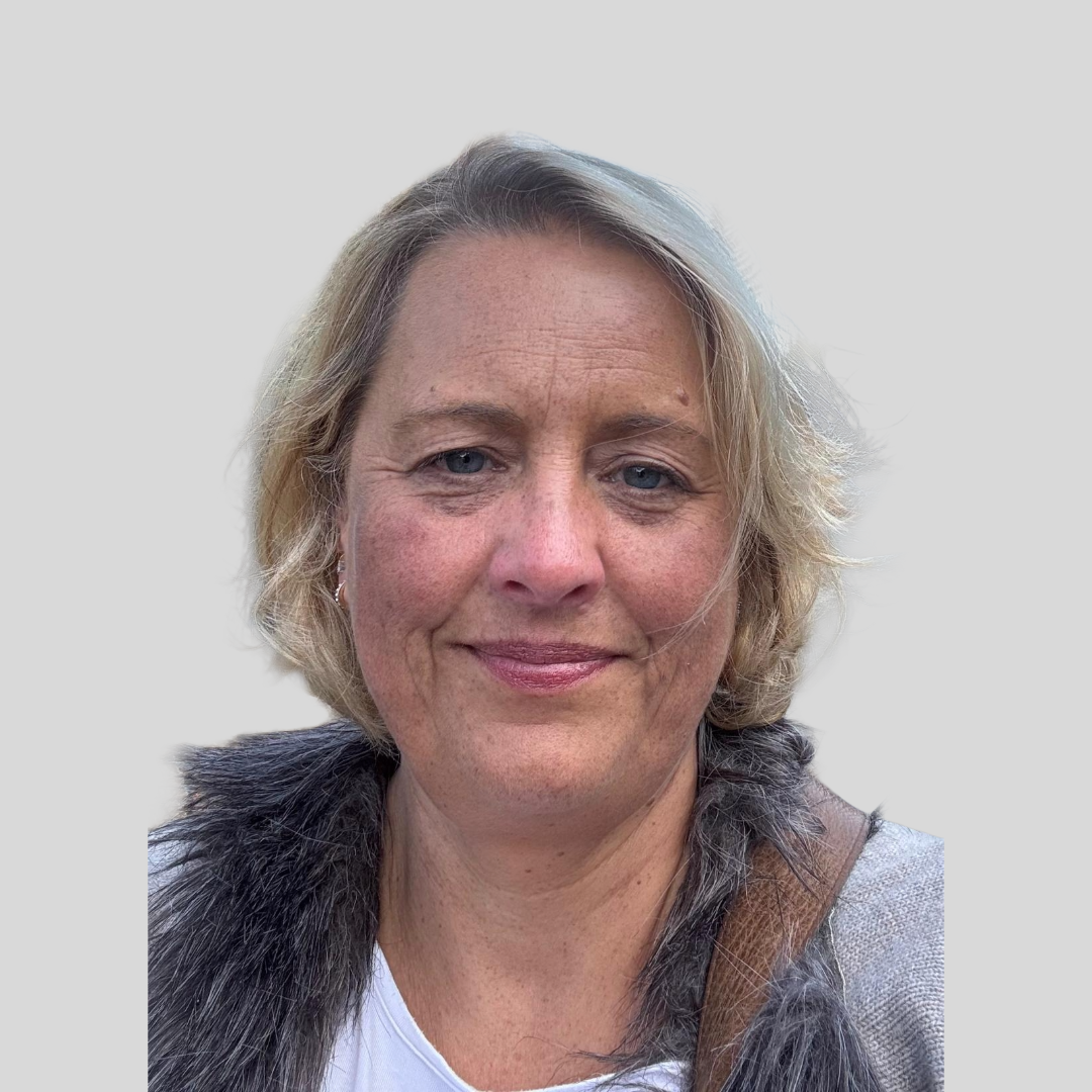 Headshot of Jo Malone who has short blonde hair and is smiling against a grey background
