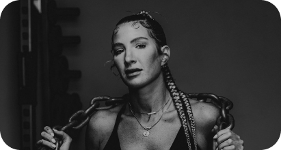 Black and white photo of Sydney with braids, holding a chain, looking at the camera.