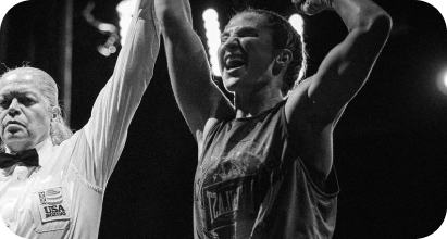 Sydney with her arms raised, smiling, after a sports victory, with an official holding her arm up in victory.