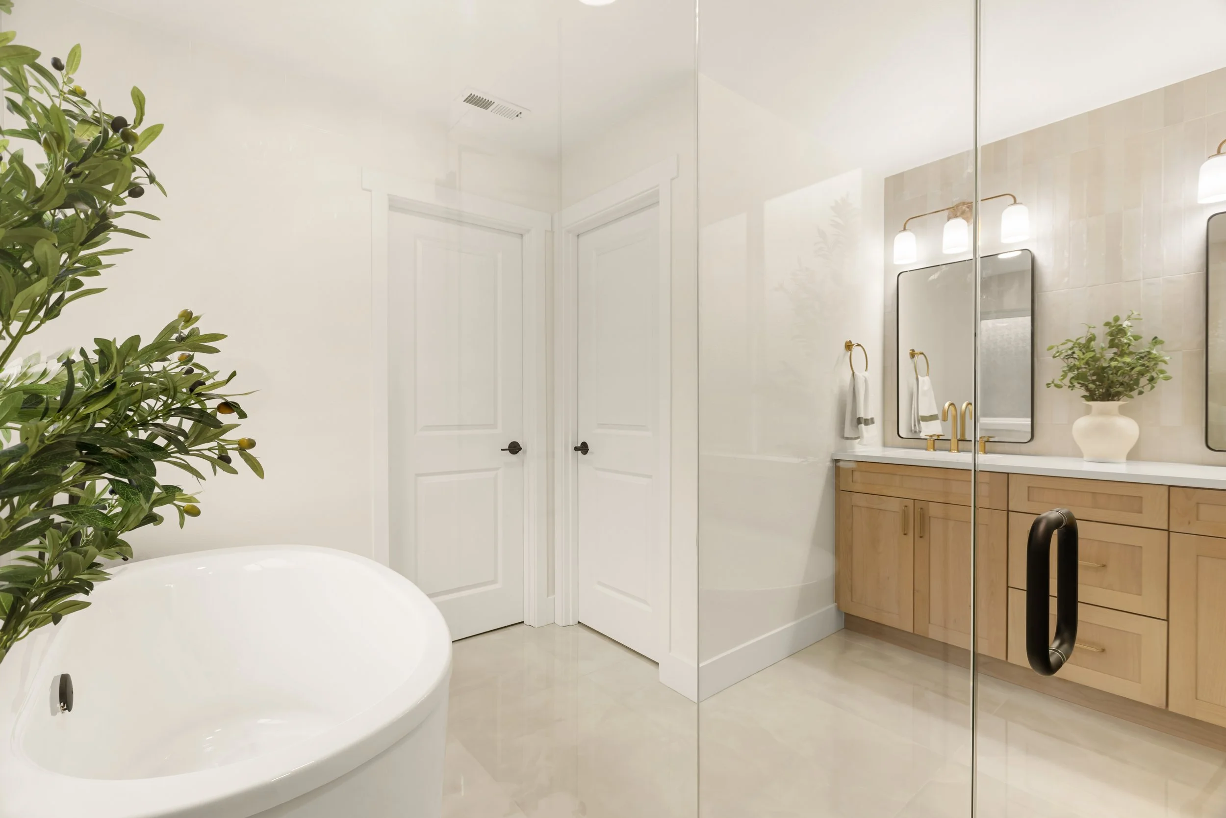 A modern bathroom with a freestanding bathtub, a large mirror, a wooden vanity, potted plant, and glass shower door.