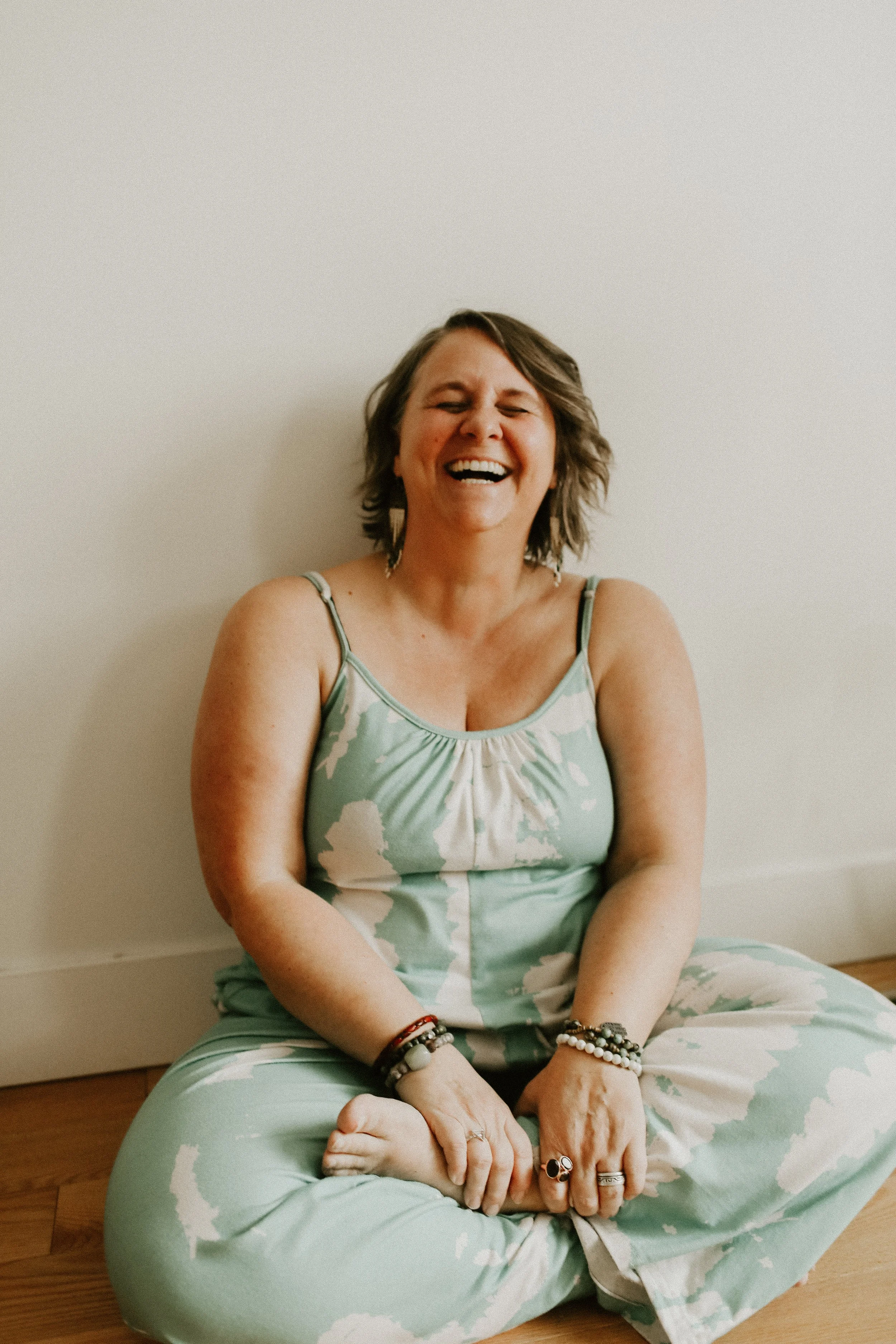 Woman laughing in her living room while loving her self