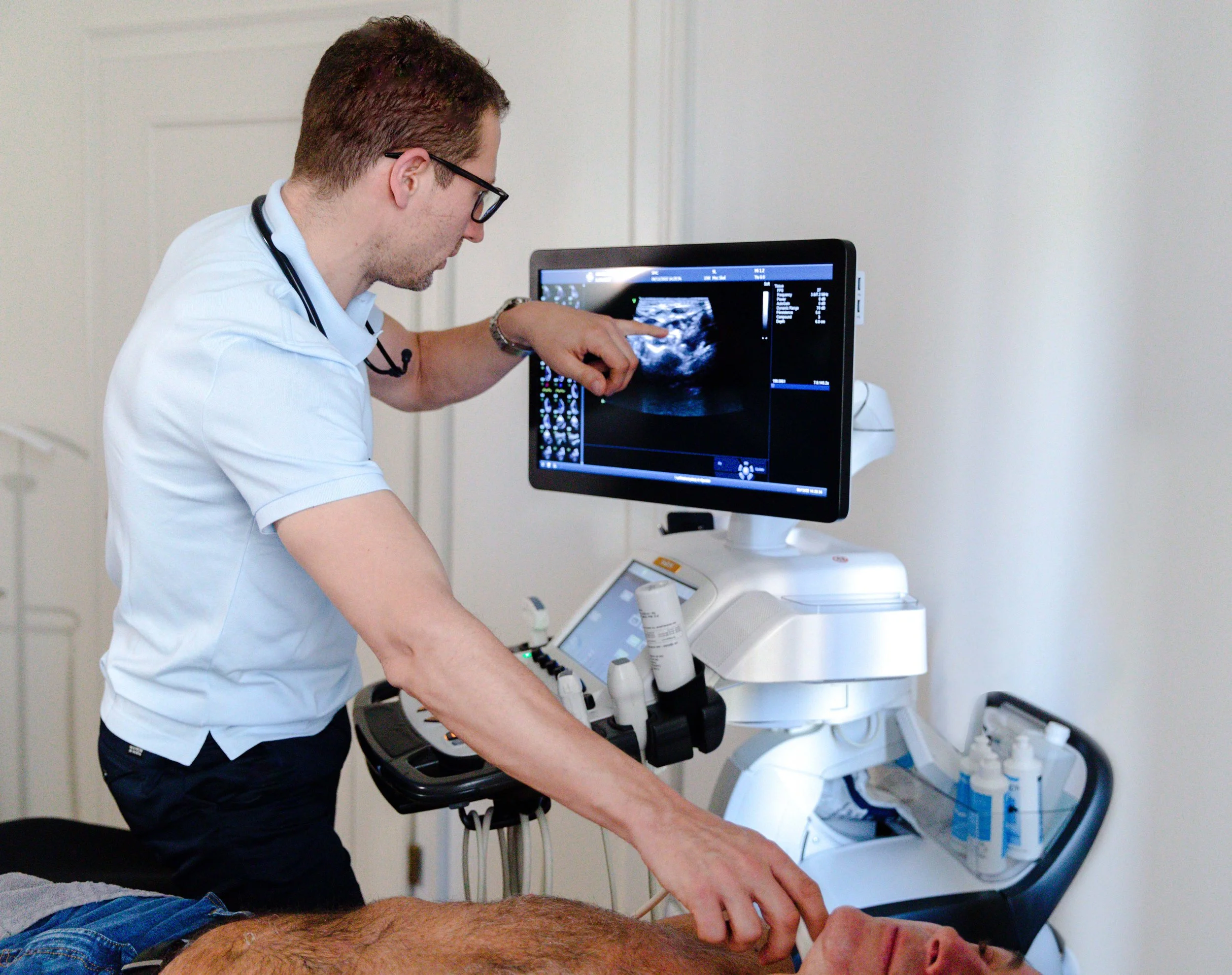 Doctor using ultrasound machine to examine patient.