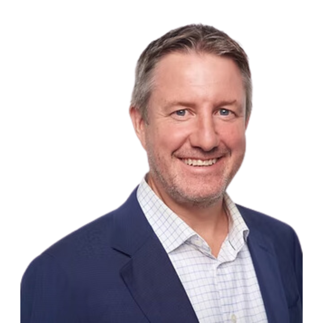 A middle-aged man with light brown hair, blue eyes, and a beard, wearing a navy blazer and white checked shirt, smiling at the camera.