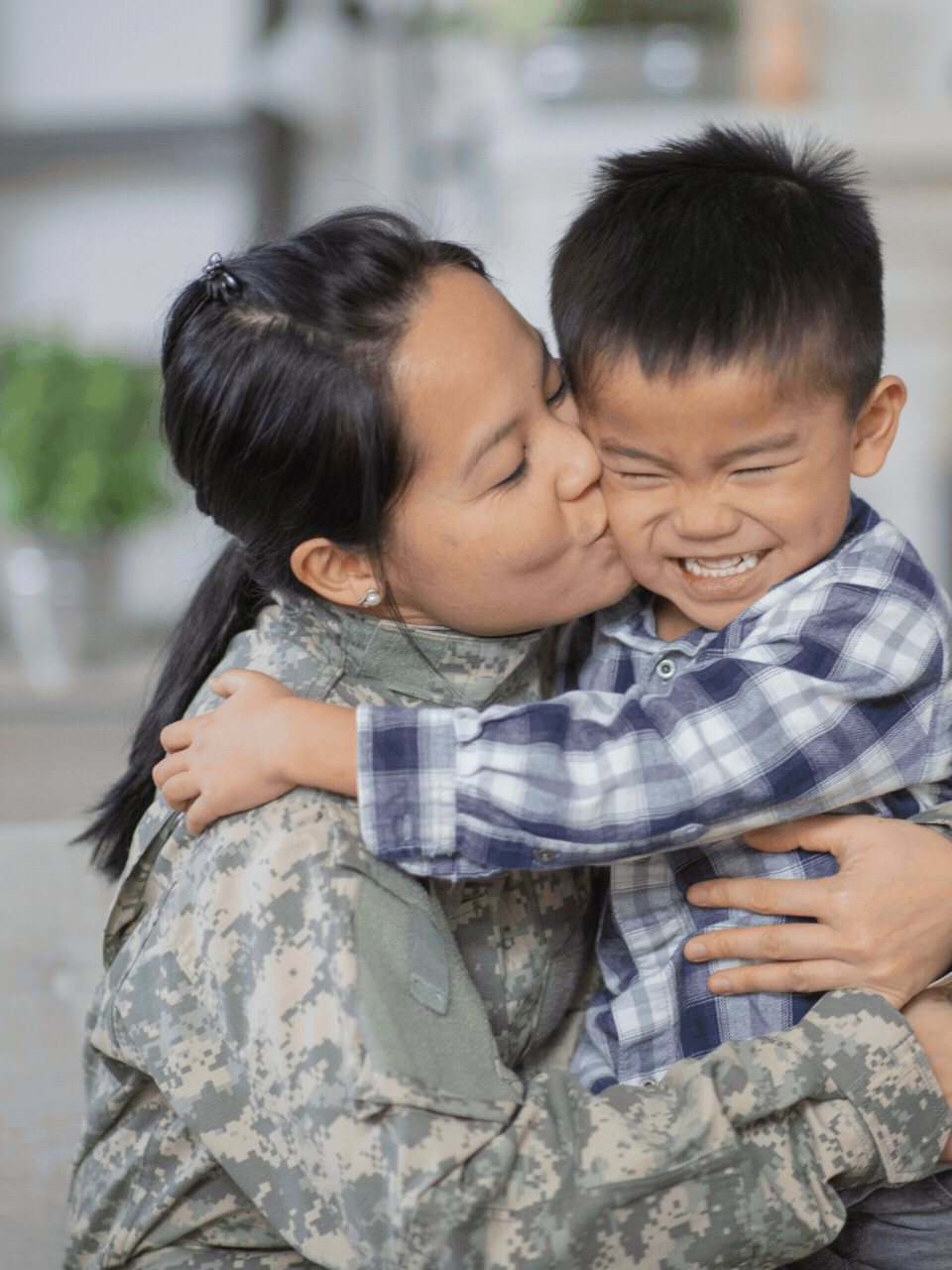 Military mother in uniform hugging her smiling son