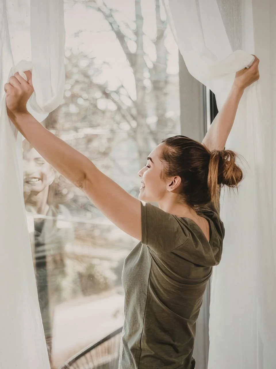 Woman stretching by a bright window in the morning