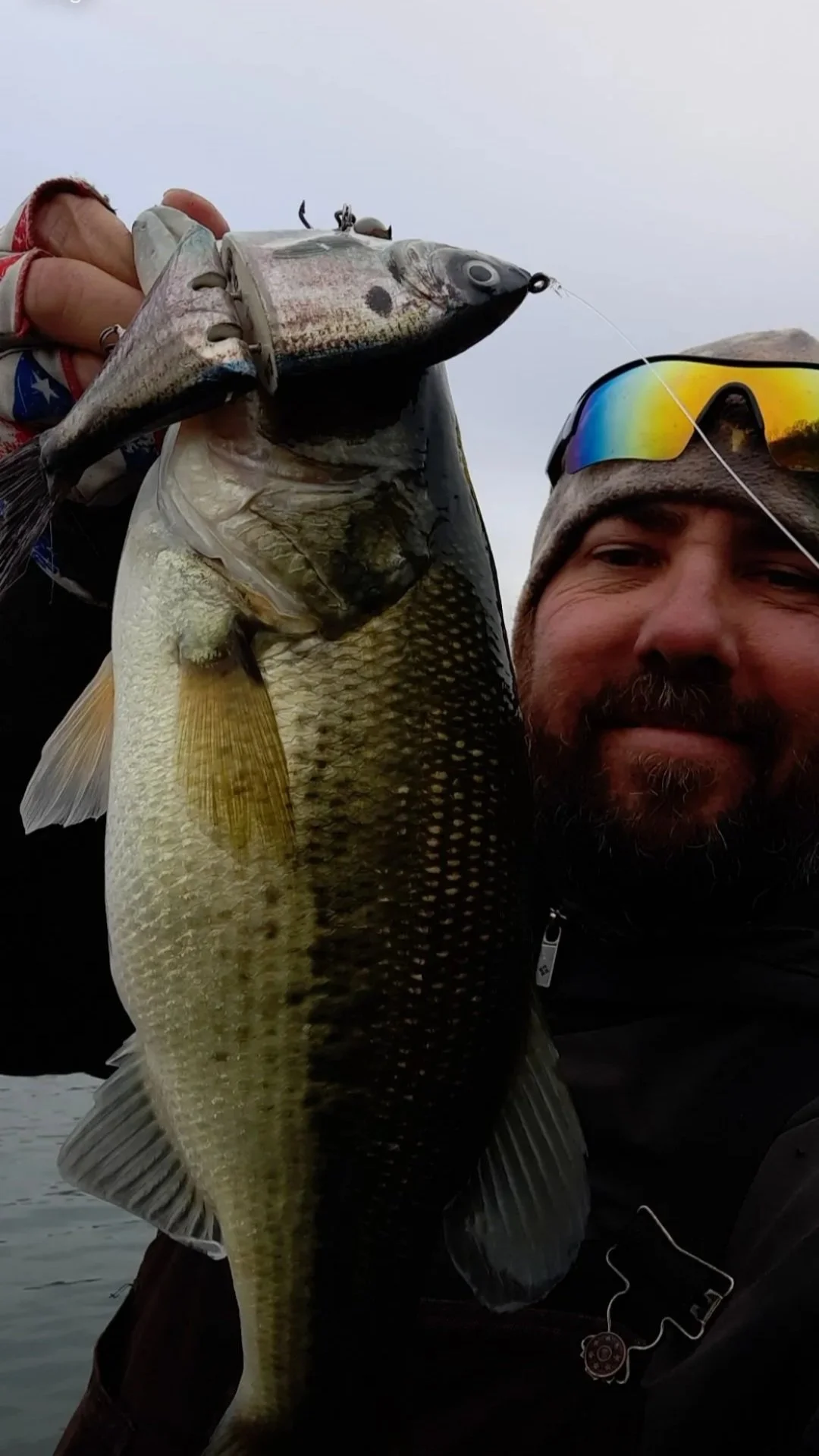 Man holding a large fish and a fishing lure.