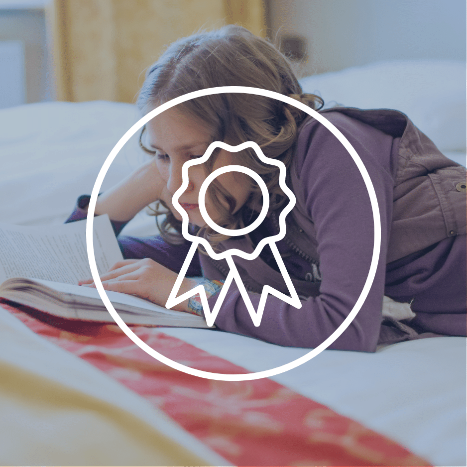 A teenage girl reading a fiction novel for the YABBA secondary school book awards.