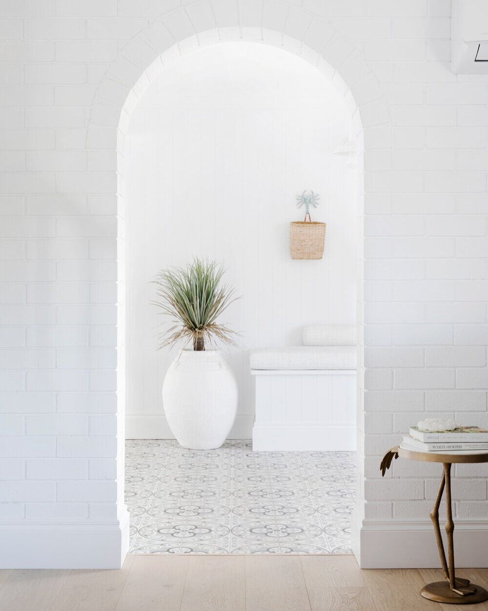 Painting your entire entranceway white works well to introduce a coastal interior style, just add lots of texture to keep it interesting. Wall lights, hooks, and patterned tiles create a fresh, welcoming vibe that's practical too.​​​​​​​​​
Source | t
