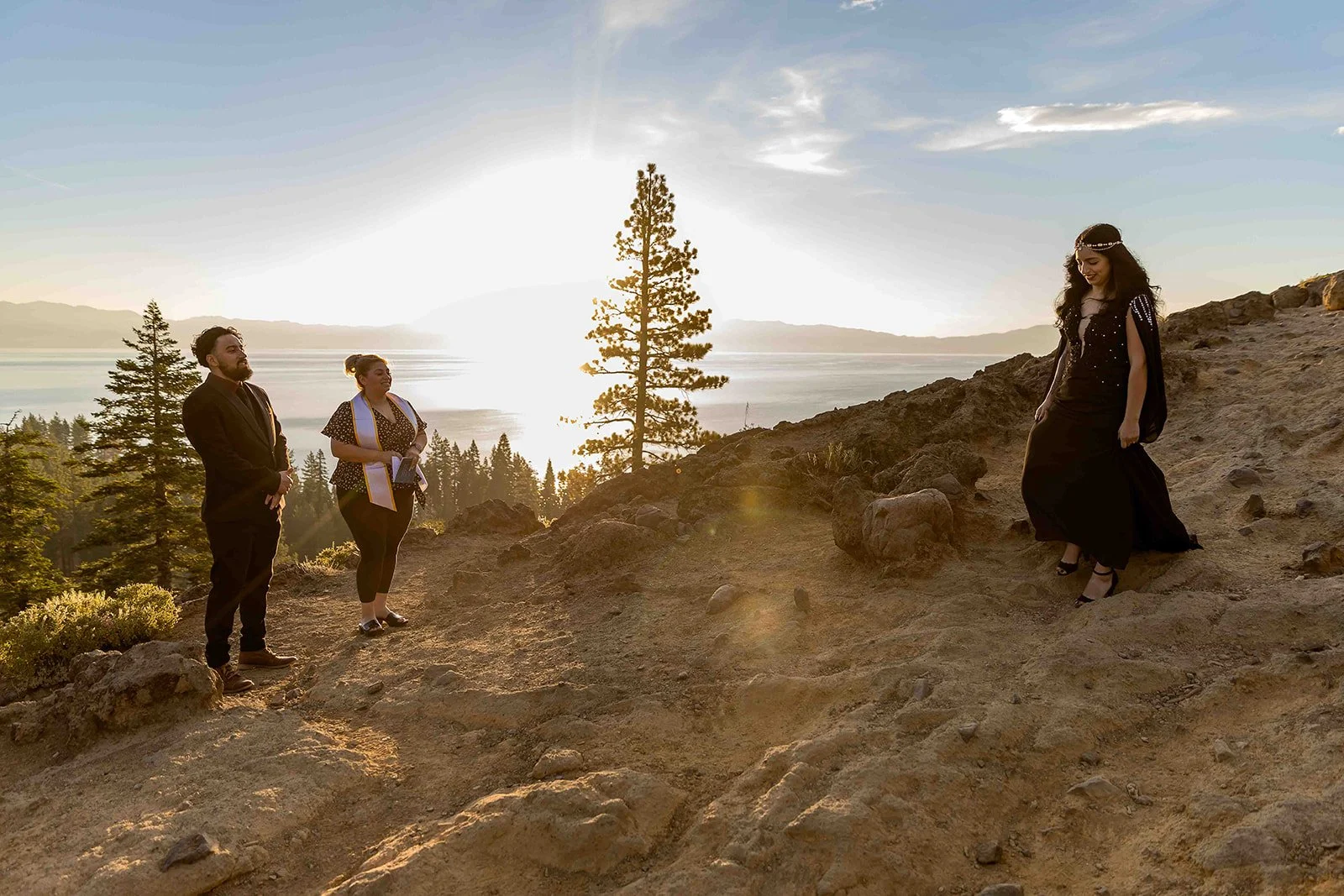 A bride wearing a black dress approaches her groom atop Eagle Rock at Lake Tahoe photographed byLake Tahoe wedding photographer Nicky Byrnes photography