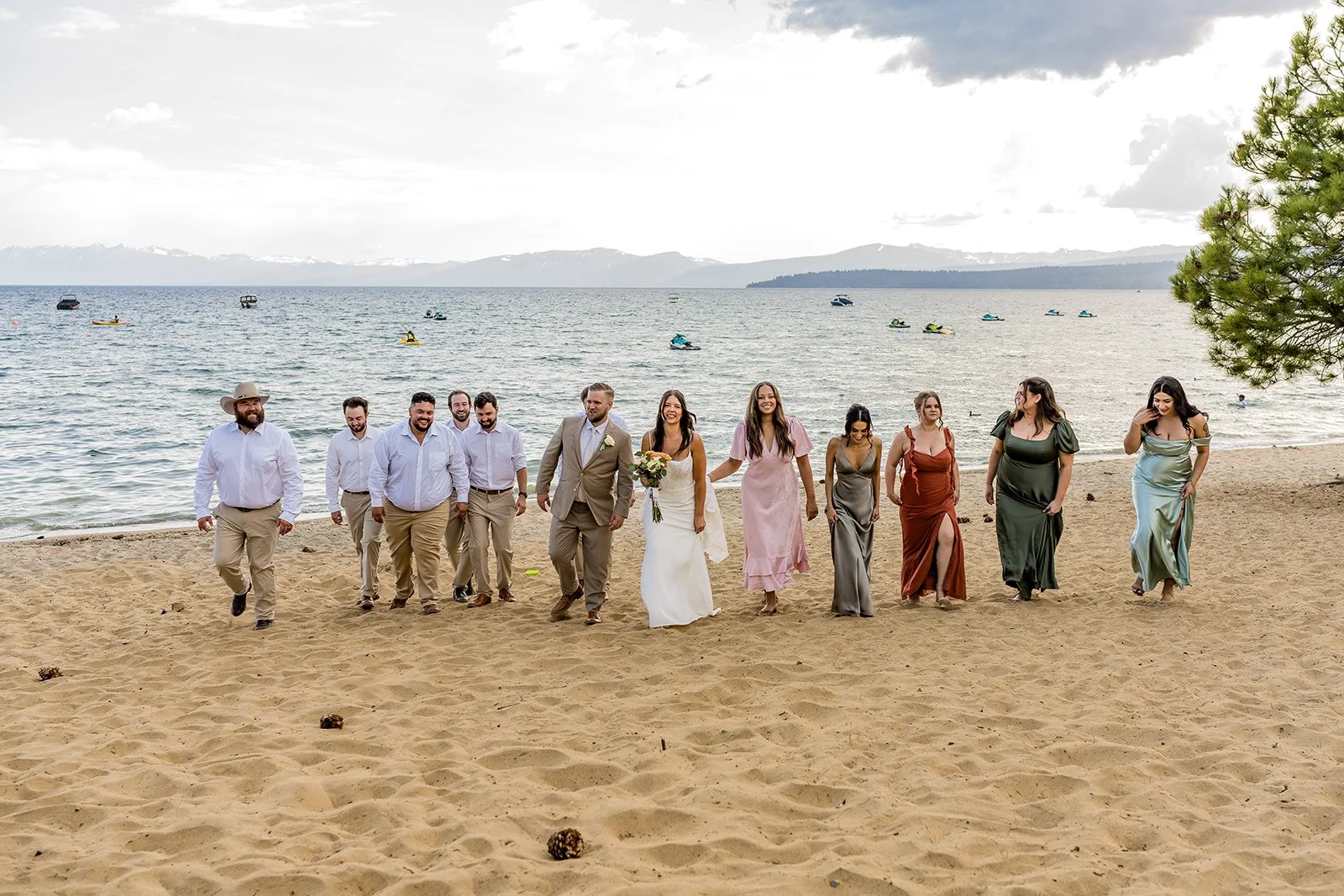  A mixed-gender wedding party walks along the beach with Lake Tahoe in the background at the North Tahoe Event Center in Kings  Beach, California. 