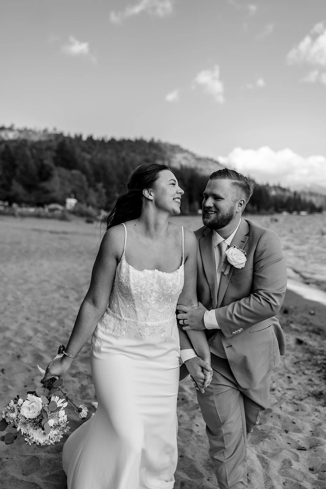  A bride and groom pictured in black and white with Lake Tahoe in the background at the North Tahoe Event Center in Kings  Beach, California. 