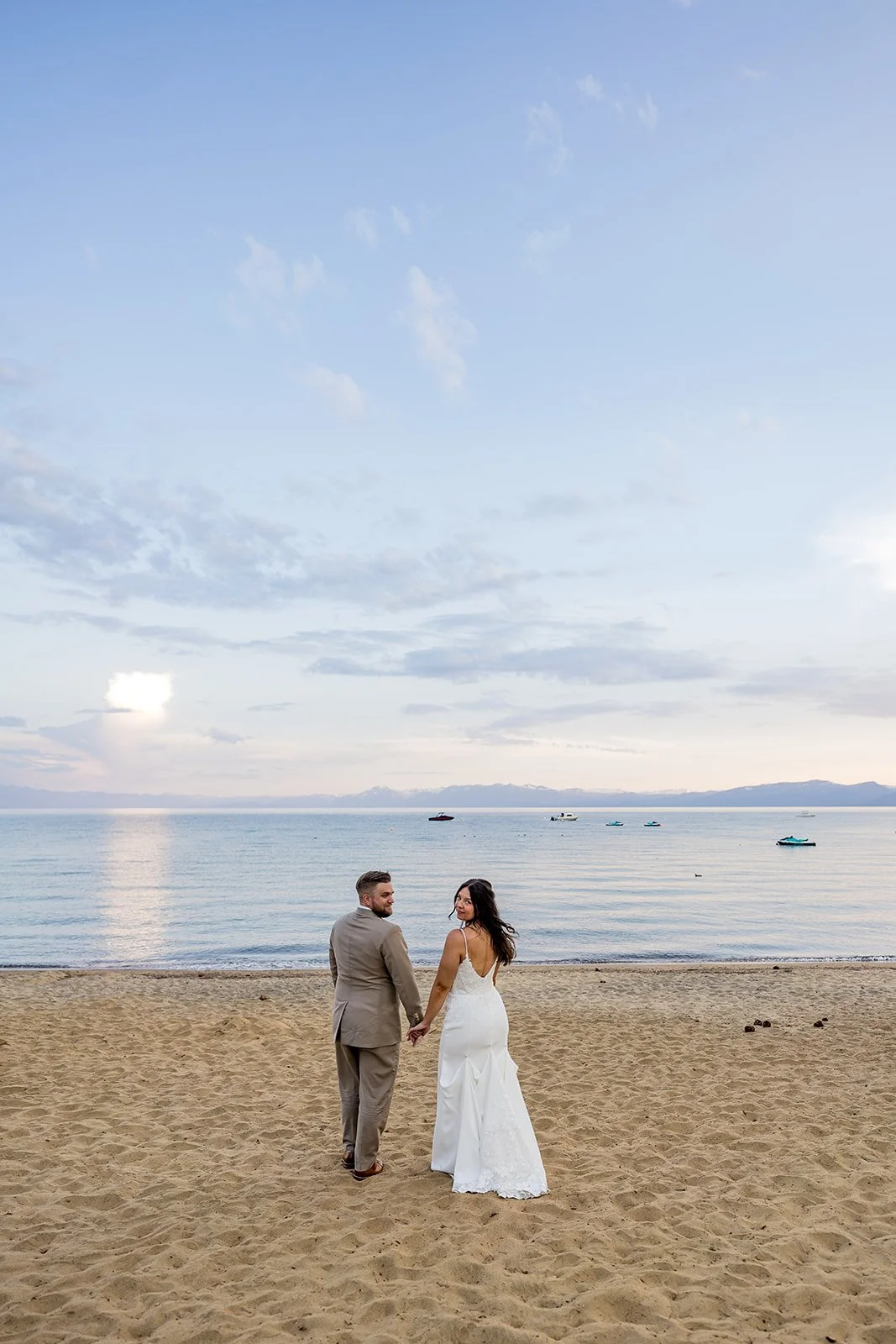 A bride and groom turn their heads while walking with Lake Tahoe in the background at the North Tahoe Event Center in Kings  Beach, California. 
