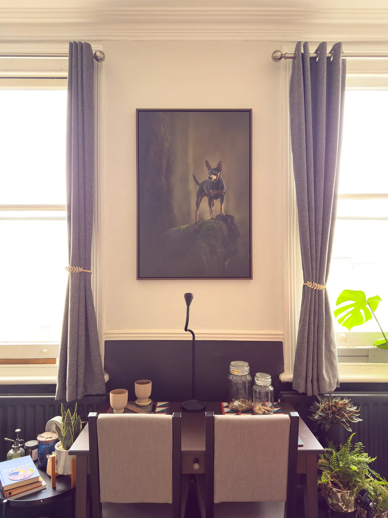 a fine art large piece of wall art on a cozy room fully of plants
