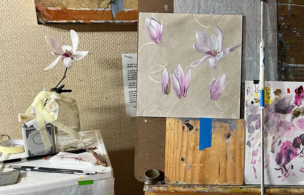 A single magnolia flower in a jar next to Christine Mercer-Vernon's painting.