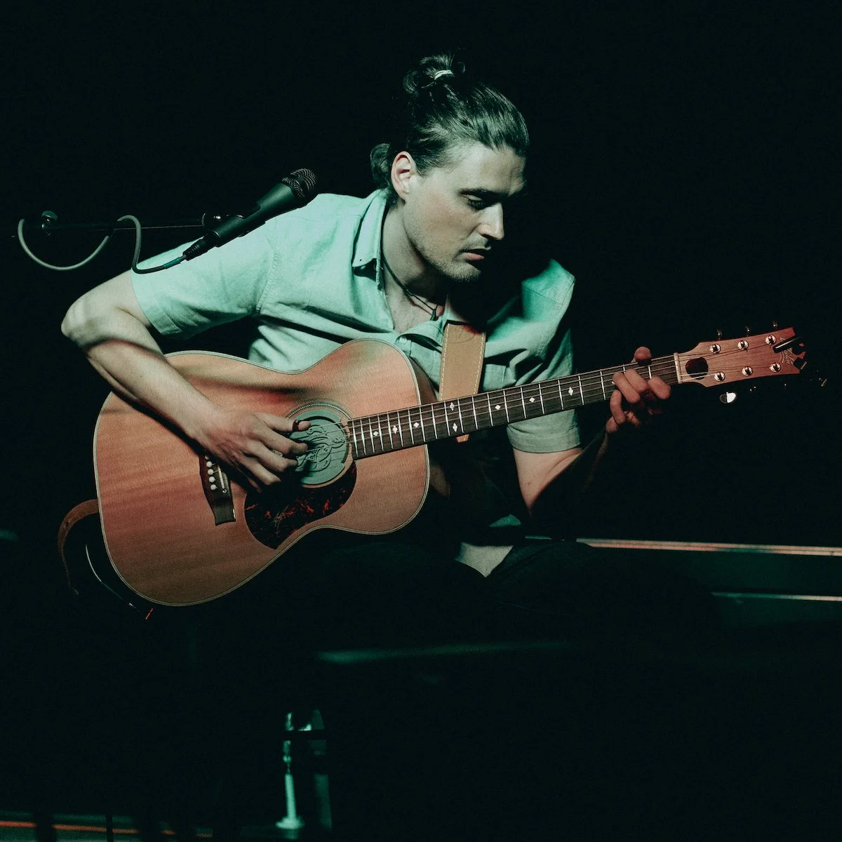 Herve Amiot joue de la guitare acoustique au concert