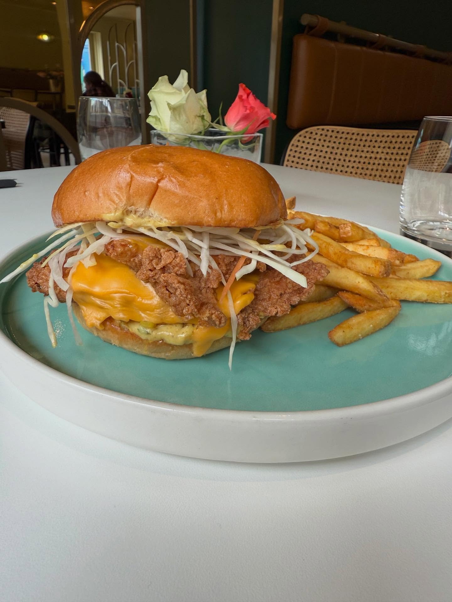 Fried chicken burger with american cheese, curry mayo, crunchy slaw + sweet onions on a brioche bun 🍗 🧀 💗
