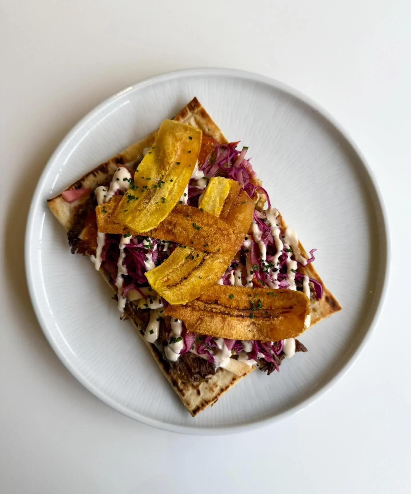 Pulled beef flatbread with slaw, sweet chilli sour cream, tomato dressing + crispy plantain 🥭 🌶️ 🍅 🍌