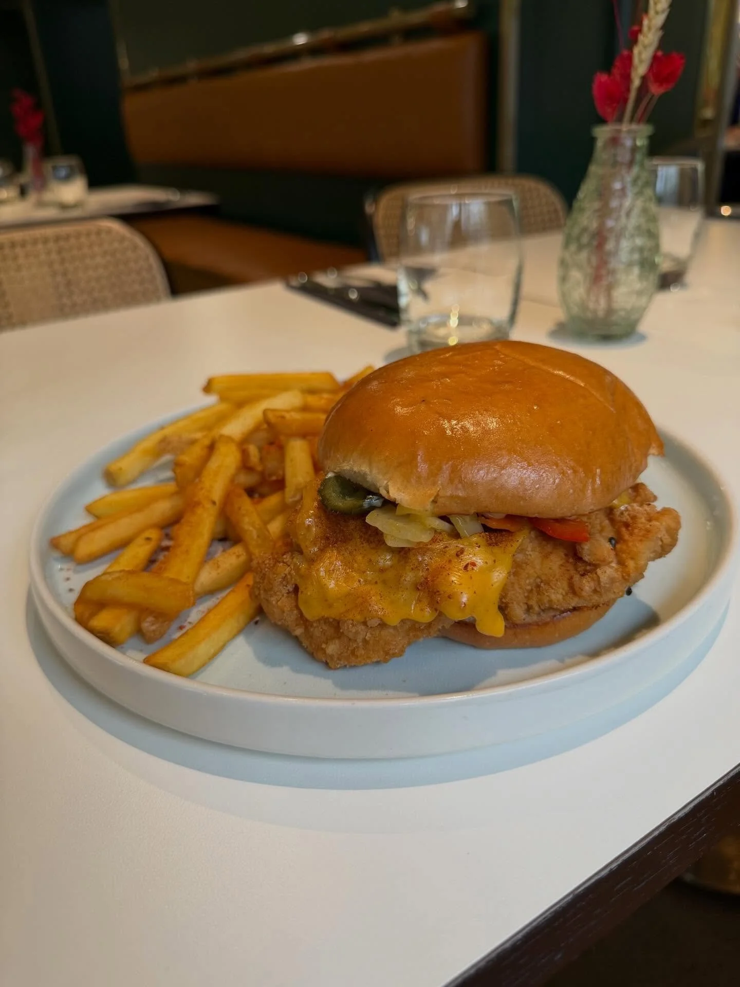 Spice Bag Chicken Burger 🍔 - fried chicken burger, American cheese, onions peppers + carrots, secret mayo 🤫, spice bag seasoning on a brioche bun with fries 🍟