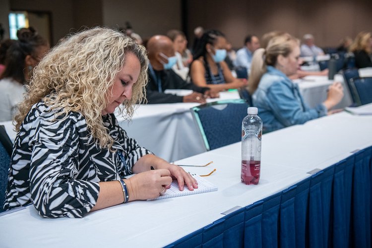 An attendee takes notes during a workshop at CruiseWorld.